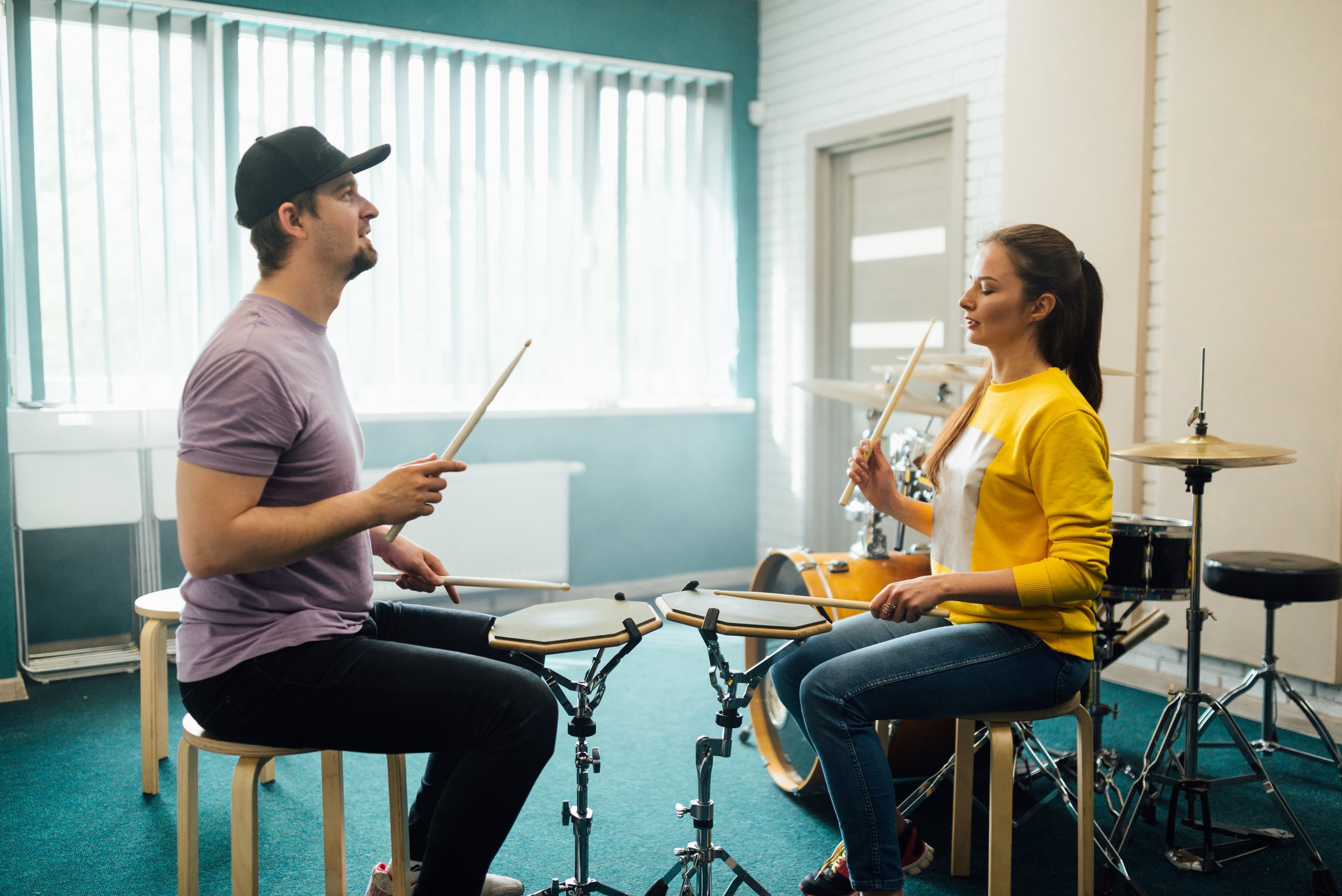 Man and Woman Practicing to Play Drum